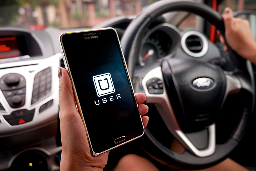 Руль и смартфон с заставкой Uber