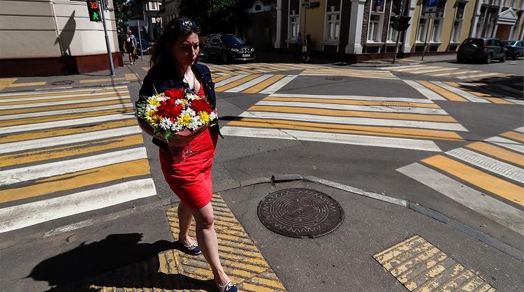 Девушка с цветами переходит дорогу