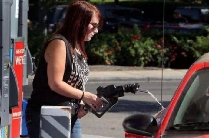 Девушка на заправке льет бензин мимо бака